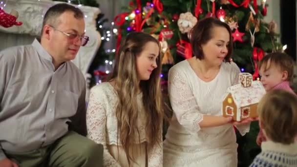 Familie schaut auf Lebkuchenhaus — Stockvideo