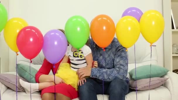 Família senta-se atrás de balões de ar — Vídeo de Stock