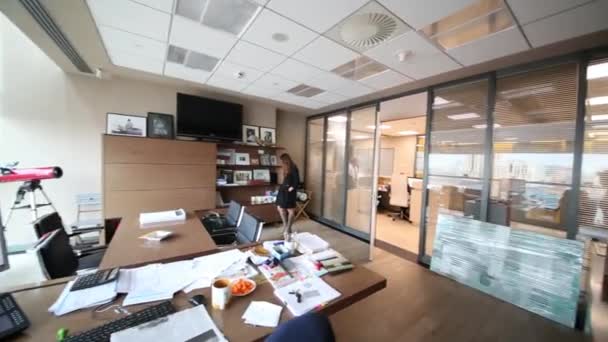 Jonge vrouw staat in moderne kantoren — Stockvideo