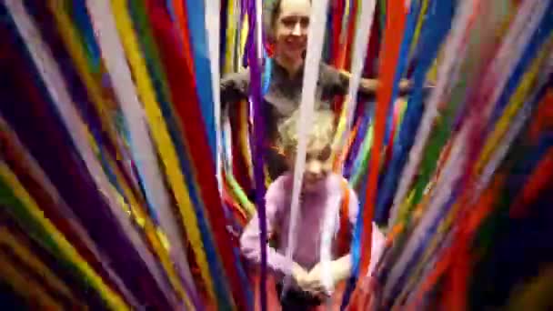 Mother and daughter go through ribbons — Stock Video