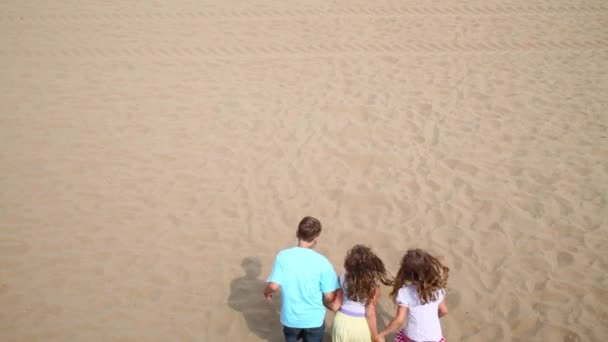 Dziatki, skoki na piaszczystej plaży. — Wideo stockowe