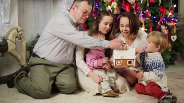 Familjen äter pepparkakshus — Stockvideo