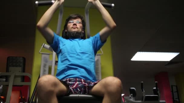 Человек выполняет упражнения на тренажере — стоковое видео