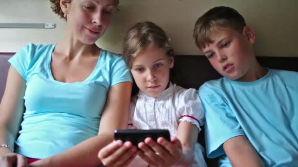 Mutter und Kinder sehen Film im Handy — Stockvideo