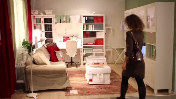 Женщина заходит в современный магазин мебели — стоковое видео