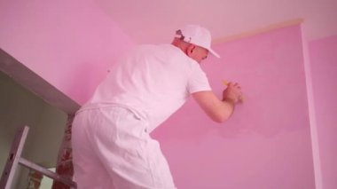 Ressam beyaz giysi ve Dizlikler çalışıyor 