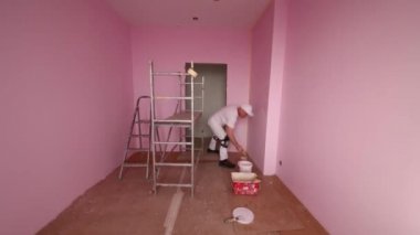 Colourer beyaz giysi ve Dizlikler çalışıyor 