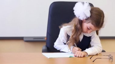 Kız yelek öğretmen masada oturur 