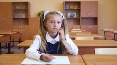 Kız sınıfta masada oturuyor 