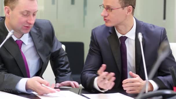 Dos hombres de negocios se sientan a la mesa — Vídeo de stock