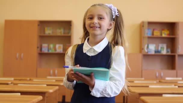 Girl in uniform holds exercise book — Stock Video