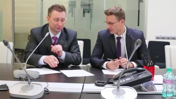 Dois empresários sentam-se na sala de reuniões — Vídeo de Stock