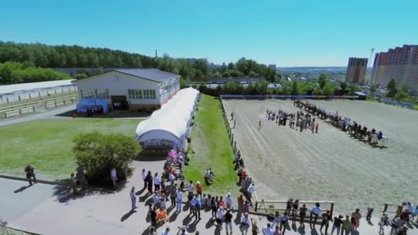 Los espectadores observan la formación de jinetes en la arena — Vídeos de Stock