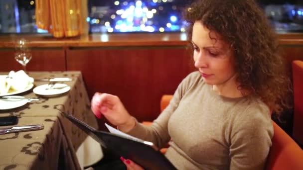 Mladá žena zkoumá menu. — Stock video