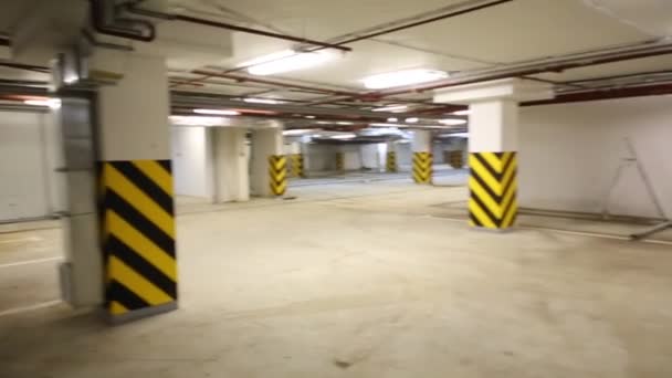 Empty underground parking with columns and pipes — Stock Video