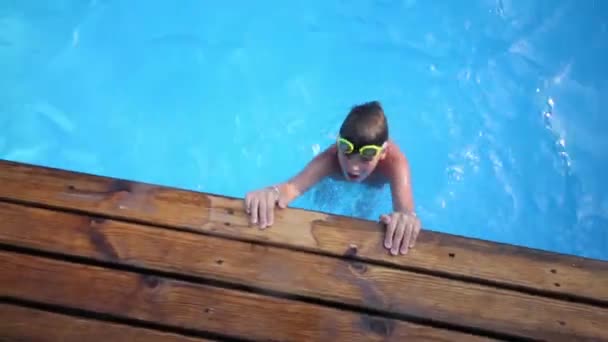 Niño en gafas de natación en la piscina al aire libre — Vídeos de Stock