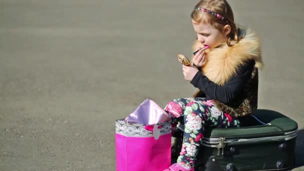 Little girl sitting on suitcase — Stock Video