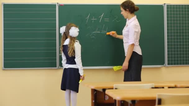 Flicka och lärare nära svarta tavlan i klassrummet — Stockvideo