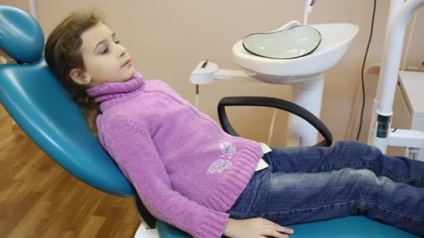 Menina senta-se na cadeira dental — Vídeo de Stock
