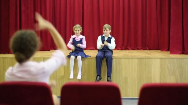 Zoon en dochter zitten op het podium — Stockvideo