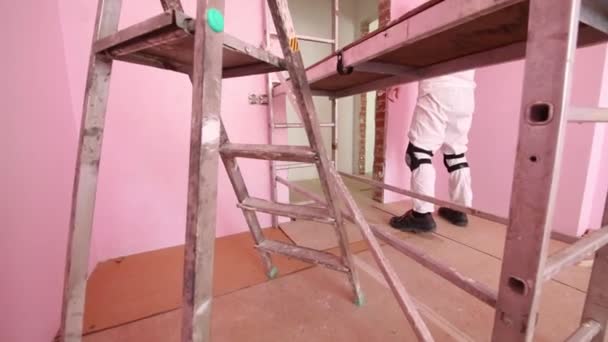 Werknemer verven muur in roze kamer — Stockvideo