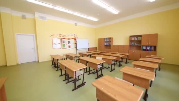 Leeres Klassenzimmer mit Holztischen und Bücherregalen — Stockvideo