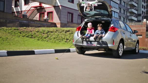 Kinder sitzen im offenen Kofferraum des Autos — Stockvideo