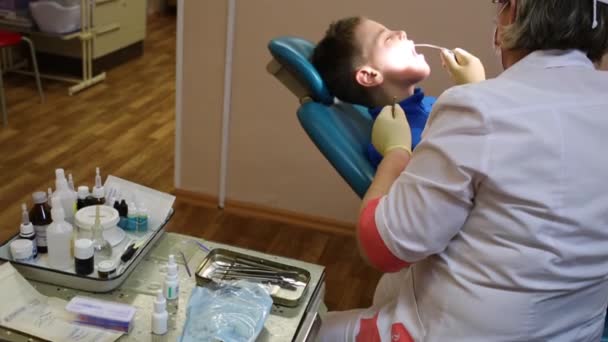 Dentista limpia los dientes de adolescente — Vídeo de stock