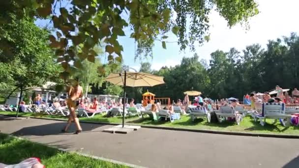 La gente toma el sol cerca de la piscina — Vídeos de Stock