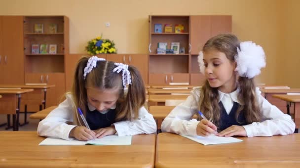 Dwie dziewczyny siedzą na Biurka szkolne — Wideo stockowe