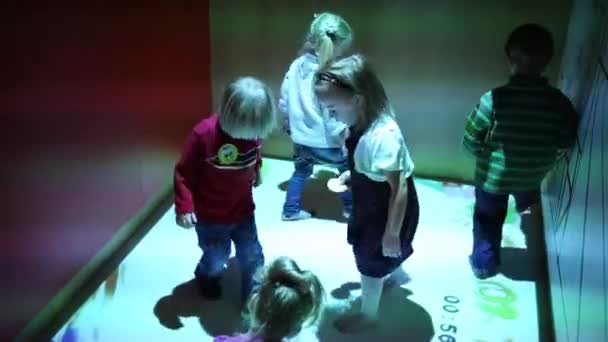 Cinq enfants jouent sur le sol interactif — Video