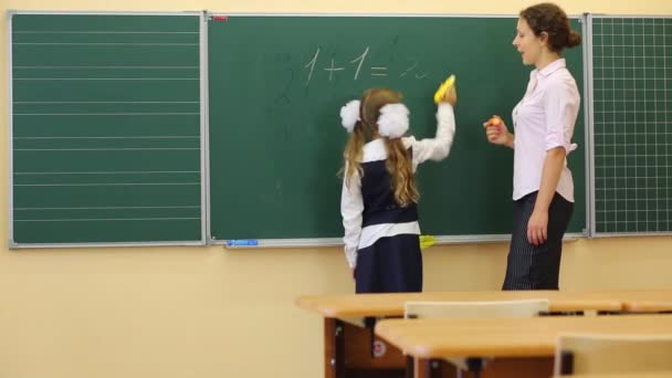 Dziewczyna i nauczyciel w pobliżu chalkboard — Wideo stockowe