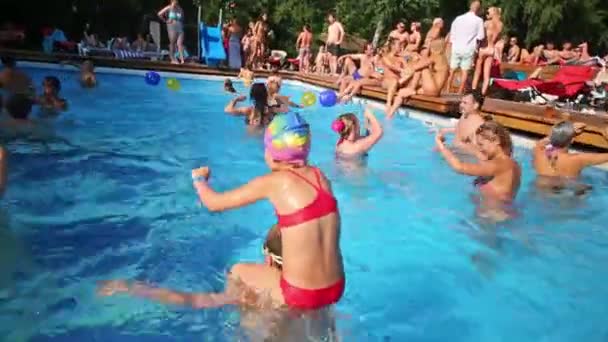 La gente juega con pelotas en la piscina — Vídeos de Stock