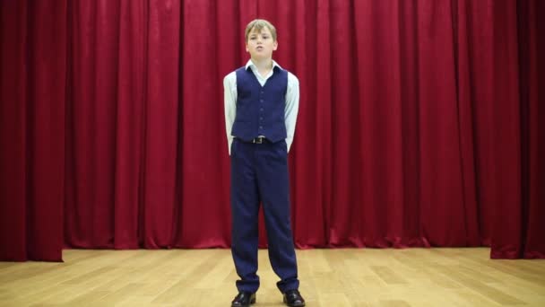 Serious boy in suit performs on stage — Stock Video