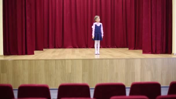 Девушка в школьной форме стоит на сцене — стоковое видео