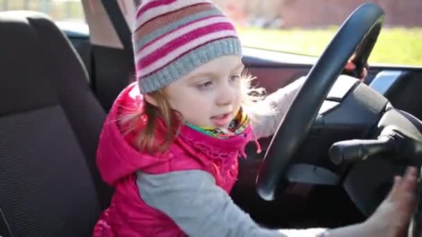 Little girl sitting at wheel of car — Stock Video