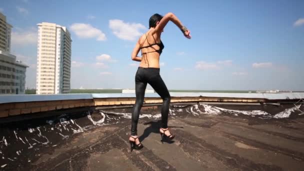 Женщина идет и танцует на крыше — стоковое видео
