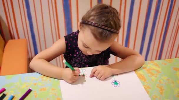 Маленькая красивая девочка рисует цветы — стоковое видео