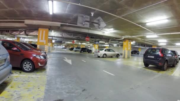 Люди и автомобили на подземной парковке — стоковое видео