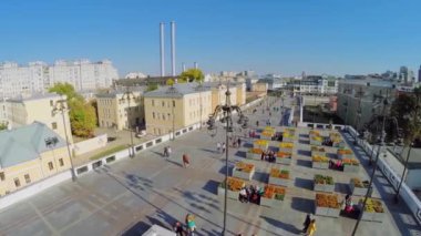 İnsanlar çiçek tarhlarına yakın yürürler. 