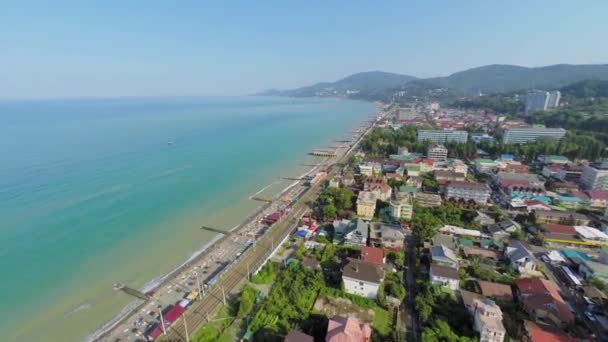 Deniz plaj üzerinde kişi ile townscape — Stok video