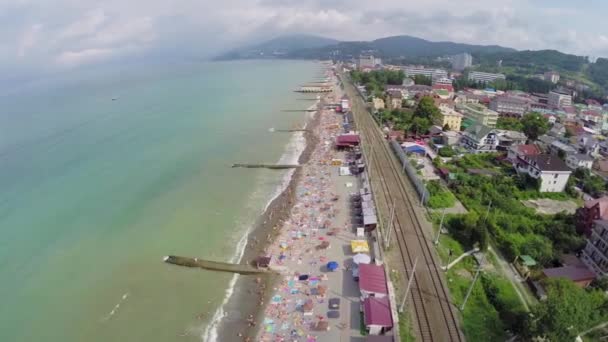 Морський пляж з людьми біля залізниці — стокове відео