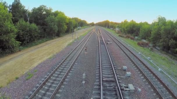 Брюнетка бегает по железной дороге — стоковое видео