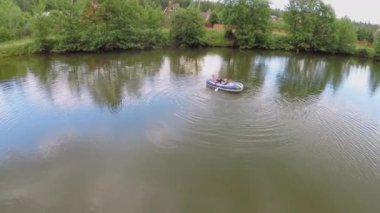 Üç çocuk şişirilmiş teknede çember