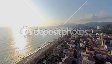 Güneş ufukta ve insanlar plajı ile deniz manzarası