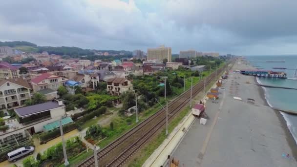 Ciudad costera con ferrocarril cerca de la playa — Vídeos de Stock