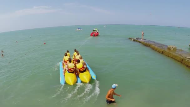 Turistas comienzan a montar en plátano inflable — Vídeo de stock