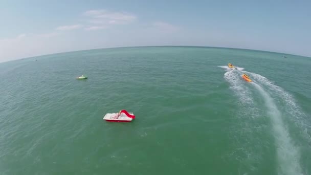 Mensen rijden op opblaasbare bananen en catamarans — Stockvideo