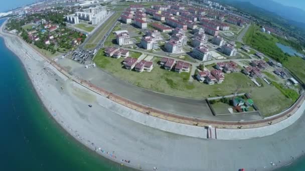 Playa del mar con gente cerca de la ciudad costera — Vídeos de Stock