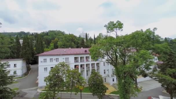 Sanatorium byggnad bland växter — Stockvideo